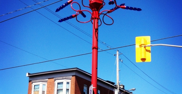 Image of a red lamppost with blue abstracted glass flowers.