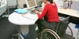 Femme handicapée en fauteuil roulant qui travaille à l’ordinateur dans un bureau