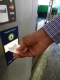 homme insérant un billet dans une machine à payer à pied