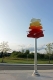 Sculpture sur poteau avec des pétales blanc, jaune, orange et rouge.