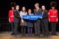 Mayor and guests holding a street sign 