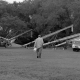 black and white photo of farmer walking toward farm machinery