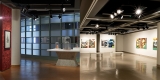 left image shows framed artwork hung on a red wallpapered wall beside small glass covered sculptures on a concrete plinth, a glass windowed wall in the background; right image shows a colorful installation of large diptych paintings hung in the space. 