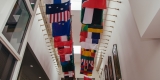 A bright atrium showcases a variety of country flags.