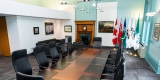 Intérieur de la salle de réunion du maire avec une longue table de réunion, des chaises et une cheminée en arrière-plan.