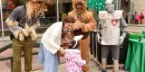 Wizard of Oz characters handing candy to child