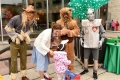 Wizard of Oz characters handing candy to child