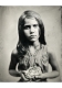 Black and white photograph of a young girl. She looks directly into the camera and holds a bird’s nest with a single white egg inside of it.