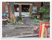 d'un caisson en acier de grand diamètre installé derrière le trottoir devant une maison.