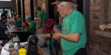 An Ottawa Tool Library volunteer in a green t-shirt and black baseball cap examines a kitchen knife. 