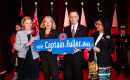 Mayor and guests holding a street sign 