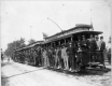 An open-car streetcar filled with passengers