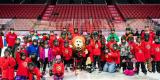 Un groupe d’enfants participant au programme « J’aime patiner » pose sur la glace du Centre Canadian Tire en compagnie de l’ambassadeur du plaisir des Sénateurs d’Ottawa, Spartacat.