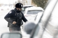 Bearded Ottawa Police Service officer talking beside a stopped vehicle in the winter. Courtesy of Ottawa Police Service./Un agent du Service de police d’Ottawa, qui a une barbe, discute à côté d’un véhicule arrêté en hiver. Fournie par la Service de Police d'Ottawa 