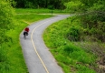 A lone cyclist rides on a bike path