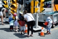 Two adults and a five children in front of traffic light display/Deux adultes et cinq enfants devant un feu de signalisation