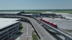 Vue aérienne de la mise à l’essai d’un train à la station Aéroport de la Ligne 4 à l’Aéroport international d’Ottawa en été avec un ciel bleu.