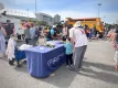 Safer Roads Ottawa table with staff talking to an adult and child/Table Sécurité des routes à Ottawa avec du personnel discutant avec un adulte et un enfant.