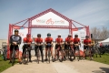 A group of eight cyclists gathered under a CN Cycle for CHEO sign.