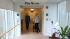 Klaske and Pamela walking away down a hallway with the name ’Elm House’ written above.