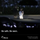 Two pedestrians in front of a car at night. 'Be safe, be seen'.