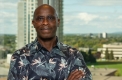 Frempon Bafi-Yeboa posing in front of a window with buildings in the background