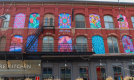 Colourful murals are painted on the windows of a three-story building