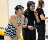 Two teen women laughing near the pool.