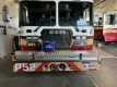 Reflective bands, bike lights and a bag on the front bumper of a fire truck/Bandes réfléchissantes, feux de vélo et sac sur le pare-chocs avant d'un camion de pompiers