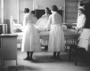 Nurses gather around a patient in bed to adjust their position