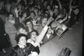 A crowd of Rock fans cheer at the stage edge.