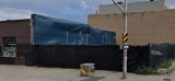 Brick building with blue wrap on a wall at 111 Parent Avenue