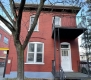 This flat roof red brick house at 143 Murray Street is located in the ByWard Market Heritage Conservation District and features Italiante detailing including brick voussoirs and a decorative cornice. 