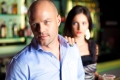 Female server with her hand on the shoulder of a man leaving the bar/Une serveuse pose sa main sur l’épaule d’un homme quittant le bar.