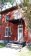 This flat roof red brick house at 143 Murray Street is located in the ByWard Market Heritage Conservation District and features Italiante detailing including brick voussoirs and a decorative cornice. 