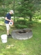 City staff measuring the water level of a large-diameter dug well using a water level tape