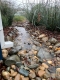 Tuyau de descente pluviale menant à un ouvrage en pierre qui canalise l’eau loin d’une maison. 