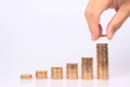 A hand stacking coins